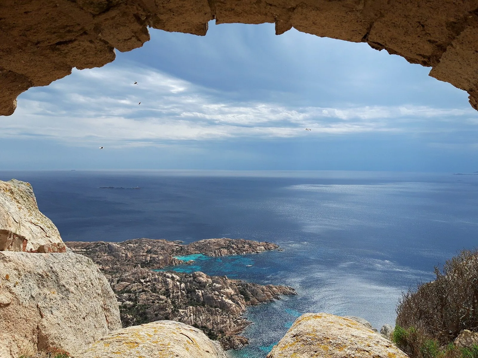Il mare e le coste di granito di Caprera visti da un'apertura nella roccia sul Monte Telajone, nel Parco Nazionale dell'Arcipelago di La Maddalena